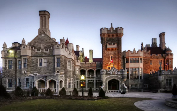 HD PC desktop wallpaper of Casa Loma: a man-made Gothic Revival castle at dusk, stone façades, towers and warm lights against a twilight sky.