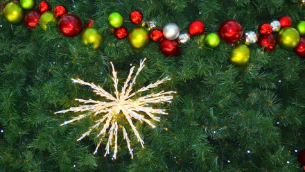 HD Christmas desktop wallpaper featuring a decorated tree with colorful baubles, festive lights, and bright holiday ornaments.