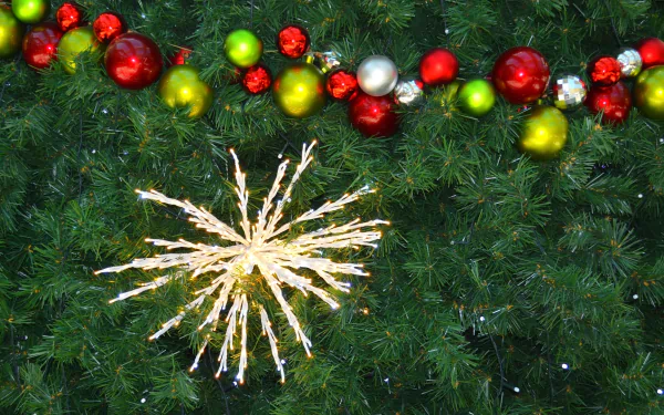HD Christmas desktop wallpaper featuring a decorated tree with colorful baubles, festive lights, and bright holiday ornaments.