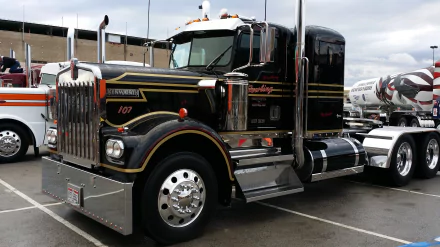 4K Ultra HD wallpaper featuring a black Kenworth truck parked in a lot under a cloudy sky, showcasing its polished chrome details and robust design.