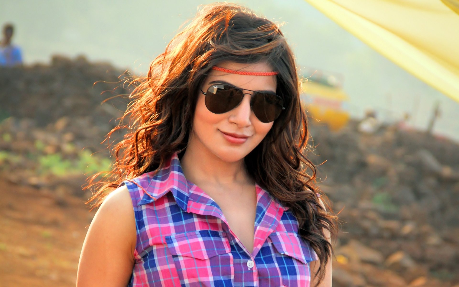 Bollywood actress Samantha Akkineni with brunette hair, wearing sunglasses and a pink plaid shirt in an outdoor setting.