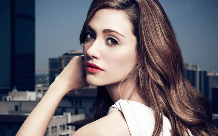 HD desktop wallpaper featuring Emmy Rossum, the American brunette actress, posing with a cityscape backdrop.