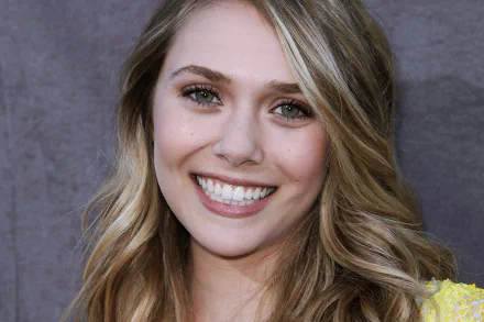 A high-definition desktop wallpaper featuring celebrity Elizabeth Olsen, showcasing her radiant smile and wavy hair against a soft background. Perfect for fans and desktop personalization.