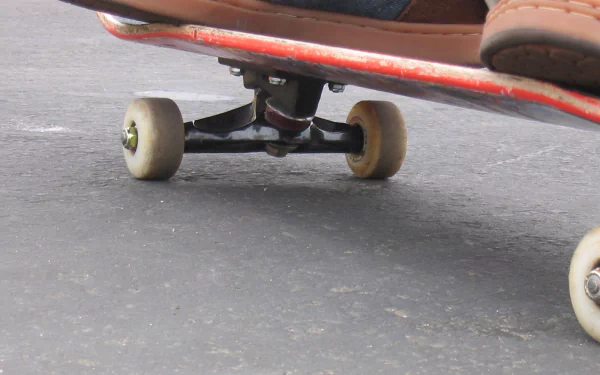 Close-up of a skateboard in motion on asphalt, captured as an HD PC desktop wallpaper showcasing the dynamic sport of skateboarding.