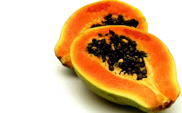 Halved papaya (pawpaw) showing bright orange flesh and glossy black seeds against a white background, HD PC desktop wallpaper and food background.