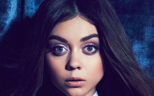 HD desktop wallpaper featuring a close-up of a woman with striking big eyes against a blue textured background.