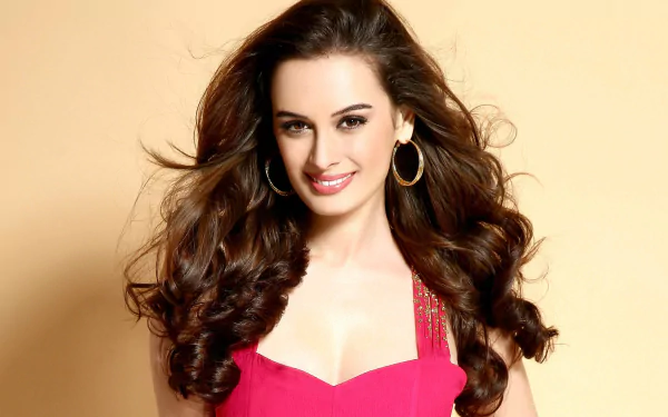A glamorous Evelyn Sharma smiles with elegance, showcasing stunning earrings in this vibrant HD wallpaper, embodying Bollywood celebrity style.