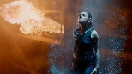 HD PC desktop wallpaper featuring Mila Kunis in a dramatic scene from the movie Jupiter Ascending, surrounded by fire and glowing particles.