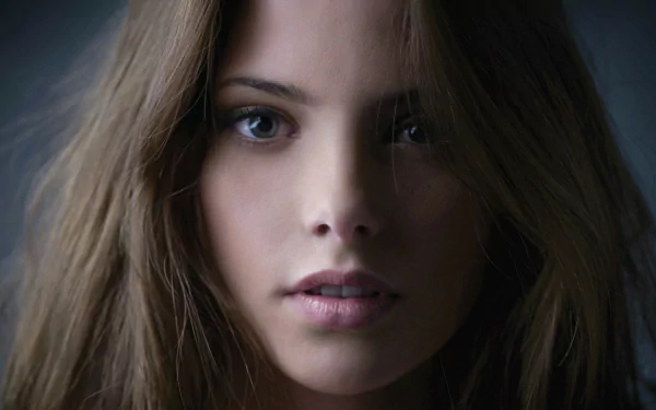 Close-up portrait of a female celebrity with long brown hair and a soft, neutral expression, presented as an HD PC desktop wallpaper/background.