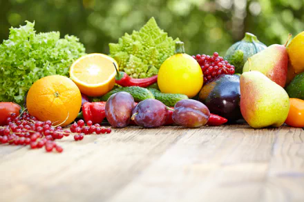 5K Ultra HD PC desktop wallpaper of food: assorted Fruits & Vegetables — oranges, pears, plums, grapes, lettuce on a wooden table, vibrant produce background.
