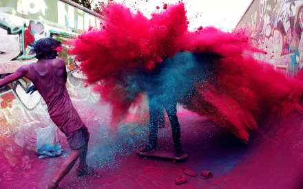 A vibrant scene from the Holi festival, featuring people playfully throwing colored powders in a graffiti-filled skatepark, creating a dynamic explosion of pink and blue hues.