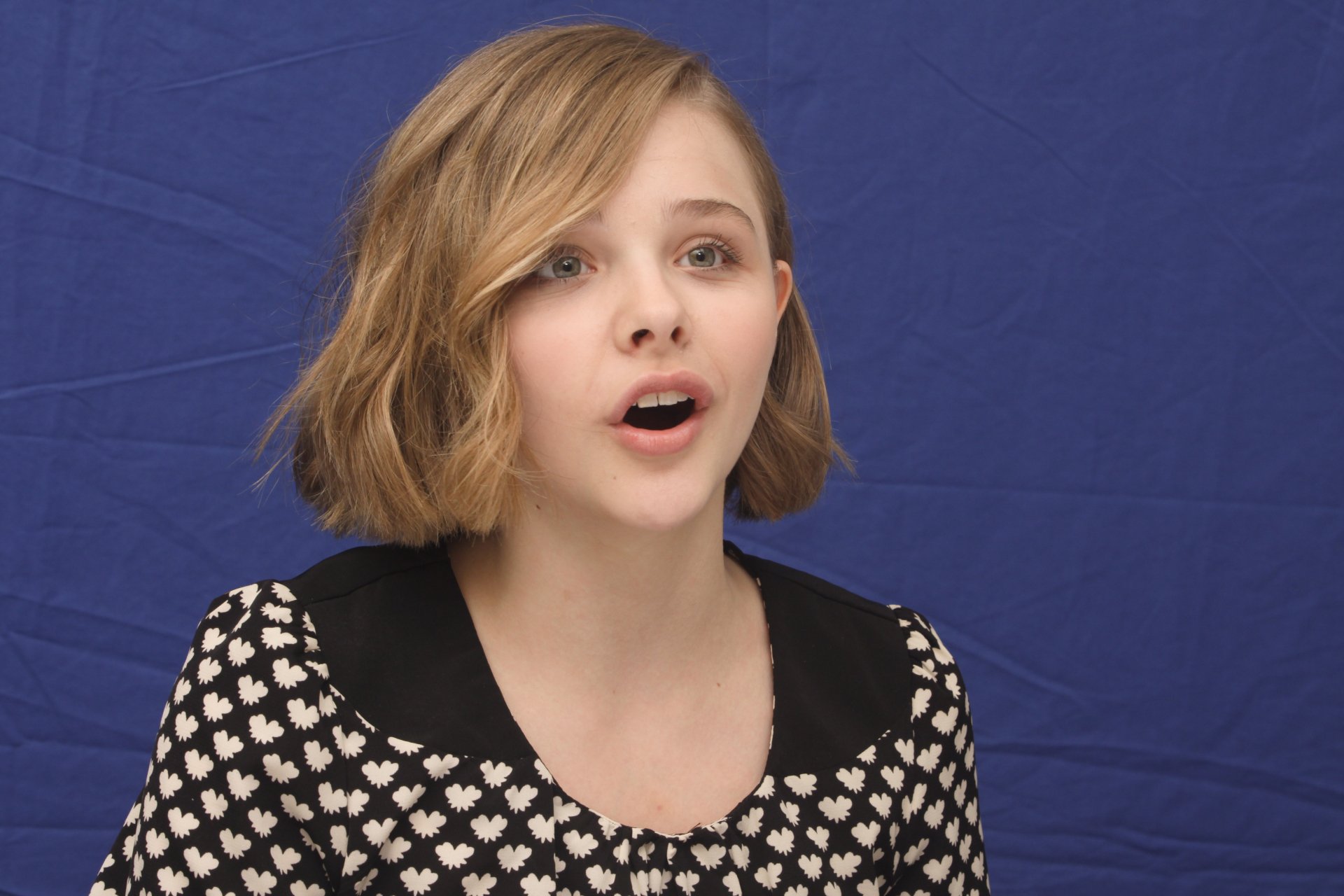 Close-up portrait of celebrity Chloë Grace Moretz against a solid blue background, featured as a 4K Ultra HD PC desktop wallpaper and background.