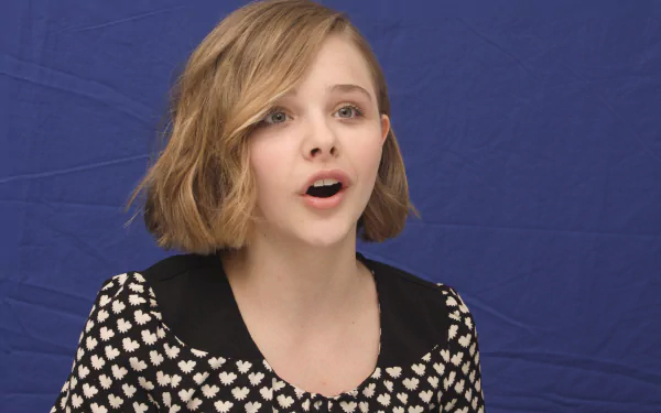 Close-up portrait of celebrity Chloë Grace Moretz against a solid blue background, featured as a 4K Ultra HD PC desktop wallpaper and background.