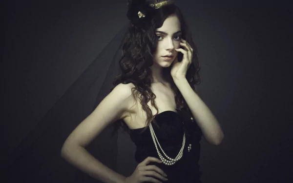 Artistic HD portrait of a woman with dark curly hair wearing a crown and a black outfit, styled as a desktop wallpaper background by Klara Koy.