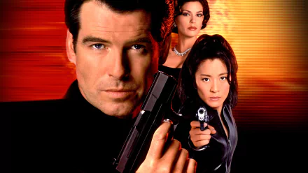 HD PC desktop wallpaper for the 007: Tomorrow Never Dies video game — close-up of a male agent holding a pistol with two female allies aiming guns against a red‑orange background.