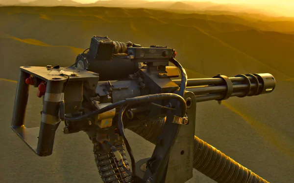 HD desktop wallpaper featuring a close-up of a man-made M134 Minigun against a sunset backdrop with rugged terrain.
