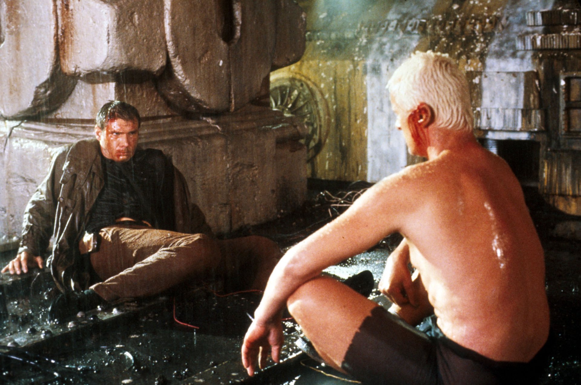 Blade Runner movie HD PC desktop wallpaper: two men in a rain-drenched rooftop standoff, one shirtless, set against a neon-lit dystopian cityscape.