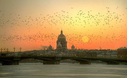 A serene winter morning in Saint Petersburg, Russia, featuring a beautiful bridge silhouetted against a sunrise, with birds soaring across the vibrant sky.