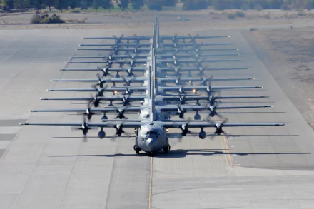 A Lockheed C-130 Hercules military aircraft lined up on a runway, showcasing its distinctive design and multiple propellers, set as a high-definition desktop wallpaper.