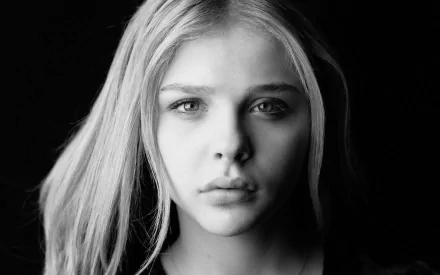 Black and white portrait of Chloë Grace Moretz, capturing her striking features and contemplative expression, serving as a captivating HD desktop wallpaper.