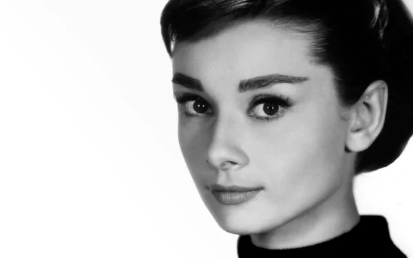Black-and-white HD desktop wallpaper featuring a close-up portrait of celebrity Audrey Hepburn with a classic, elegant expression.