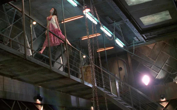 Serenity (2005) movie HD PC desktop wallpaper and background: woman in a pink dress walks a metal catwalk inside the ship, industrial interior lit by harsh, dramatic lights.