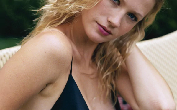 Close-up HD desktop wallpaper of celebrity January Jones with wet blonde hair, wearing a black top, posing outdoors against a blurred natural background.