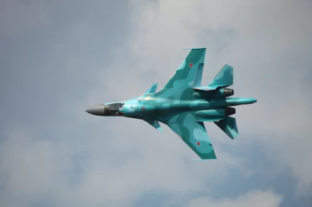 4K Ultra HD wallpaper featuring a military Sukhoi Su-34 fighter jet soaring through a cloudy sky.