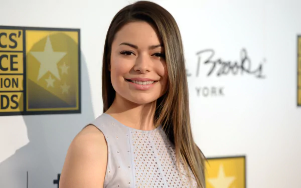 HD PC desktop wallpaper featuring a smiling celebrity Miranda Cosgrove at a media event with branded backdrop.