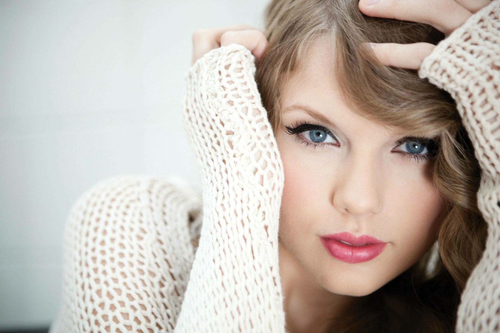 HD desktop wallpaper featuring a fantasy-inspired close-up of an American singer with blonde hair and blue eyes, wearing a white knit sweater.