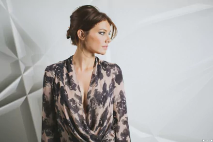 Lauren Cohan posing elegantly in a stylish outfit against a textured background, captured in a high-definition desktop wallpaper.