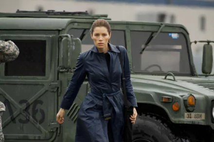 Jessica Biel strides confidently in a sleek jacket next to a military vehicle, capturing a moment from the movie *The A-Team*. HD desktop wallpaper featuring action and intensity.