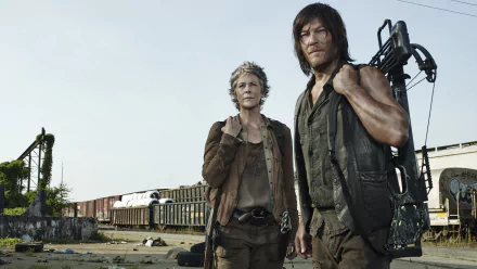 A high-definition wallpaper from the TV show The Walking Dead, featuring two main characters standing in a desolate landscape with abandoned train cars in the background.