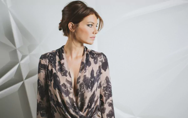 Lauren Cohan posing elegantly in a stylish outfit against a textured background, captured in a high-definition desktop wallpaper.