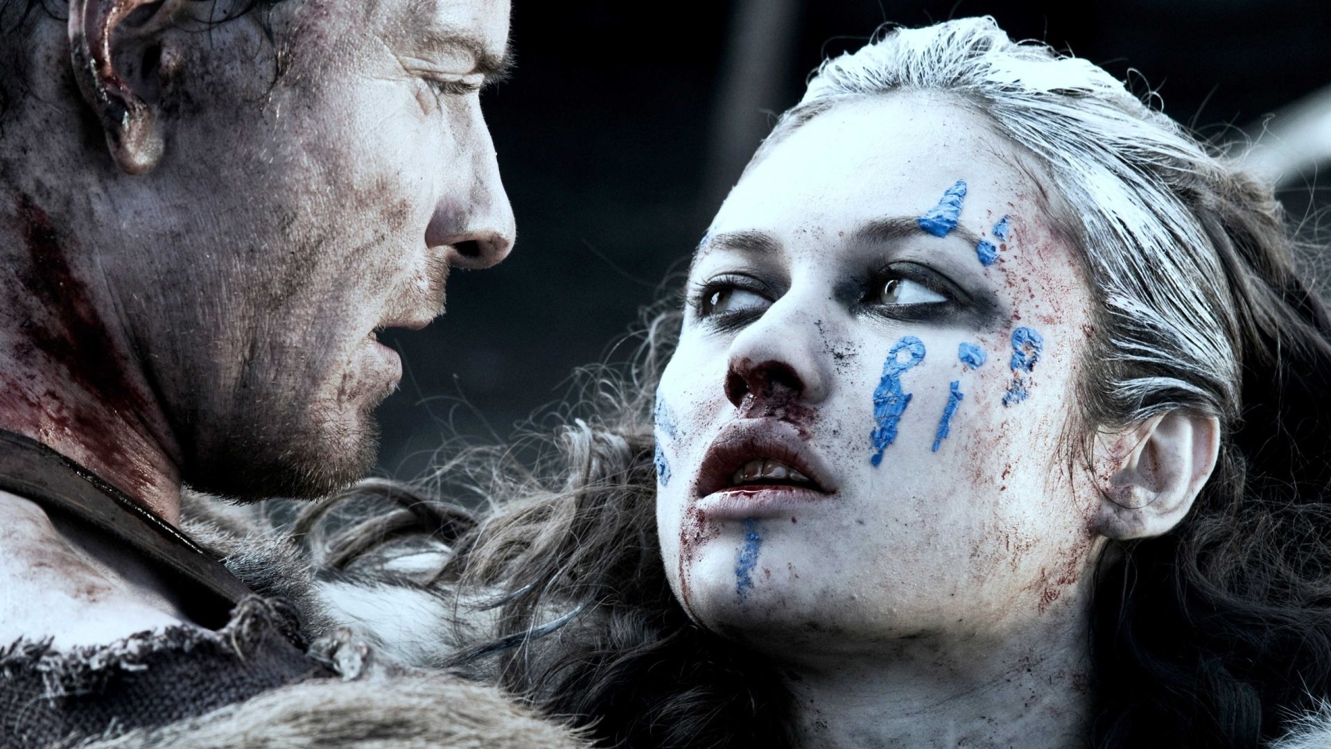 Movie Centurion 2K Quad HD PC desktop wallpaper/background: close-up of a bloodied woman with blue war paint staring up at a fellow soldier, tense and gritty battlefield mood