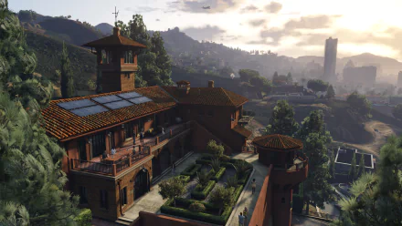 A high-definition Grand Theft Auto V desktop wallpaper featuring a scenic view of a luxurious mansion and surrounding landscape at sunset.