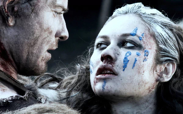 Movie Centurion 2K Quad HD PC desktop wallpaper/background: close-up of a bloodied woman with blue war paint staring up at a fellow soldier, tense and gritty battlefield mood