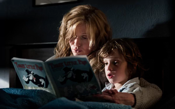 Essie Davis and Noah Wiseman in a dark, intense scene from the movie The Babadook, featured as a 4K Ultra HD PC desktop wallpaper.