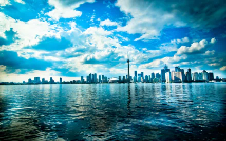 HD desktop wallpaper featuring the man-made skyline of Toronto with the CN Tower under a vibrant, partly cloudy sky reflected on the water.