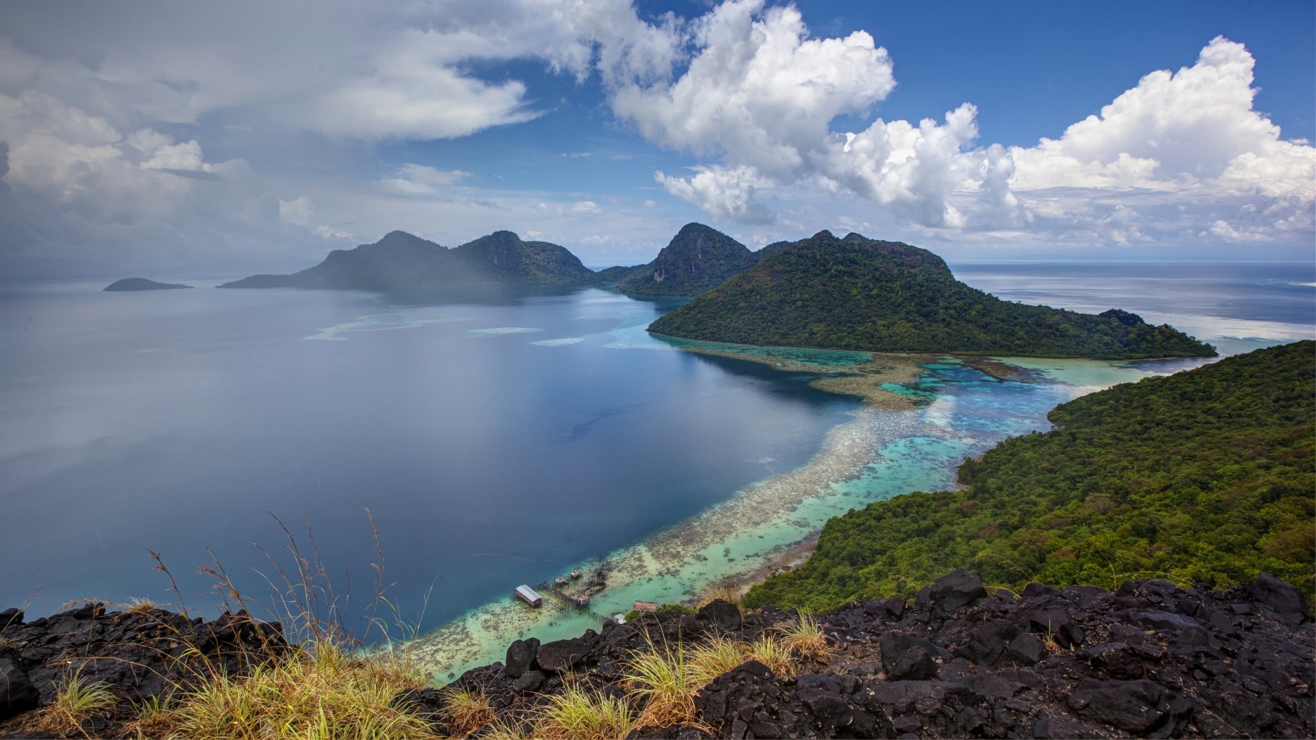 A stunning seascape of the Selu Sea in Borneo, Malaysia, showcasing lush tropical islands, clear waters, and dramatic clouds, captured in vibrant 4K Ultra HD detail.