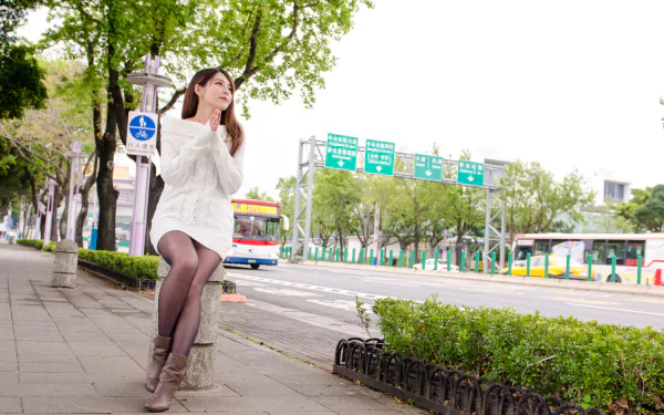 A Taiwanese woman model, Julie Chang (Zhang Qi Jun), stands on a street in an urban setting, captured in 4K Ultra HD for a PC desktop wallpaper.