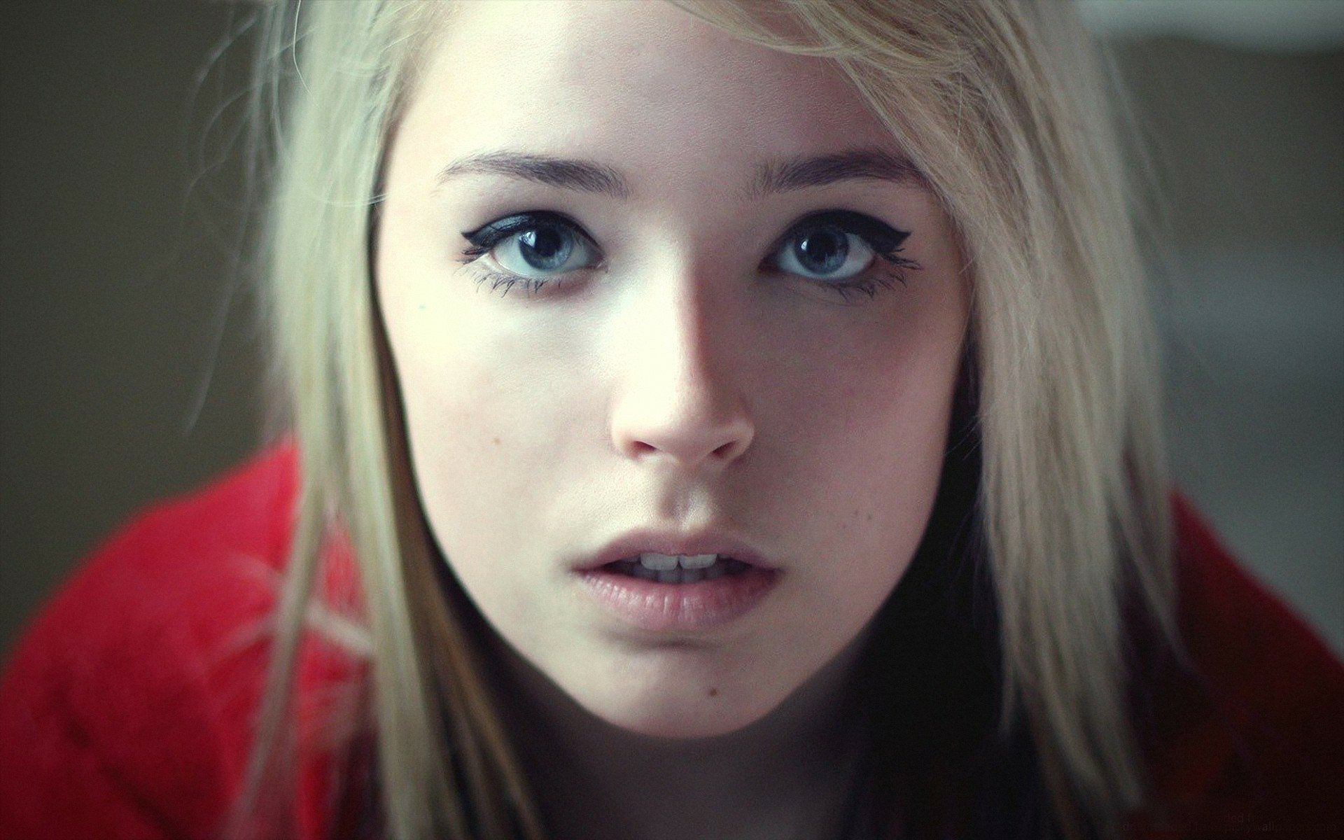 A captivating portrait of a blonde woman with striking blue eyes, conveying emotion and depth. This HD image serves as a stunning desktop wallpaper or background.