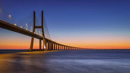 Sunset over the Vasco da Gama Bridge in Portugal, spanning the calm sea, captured in stunning 4K Ultra HD.