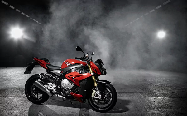 A striking red BMW S1000 motorcycle showcased against a smoky backdrop, illuminated by dramatic lighting. This HD image serves as a captivating desktop wallpaper.