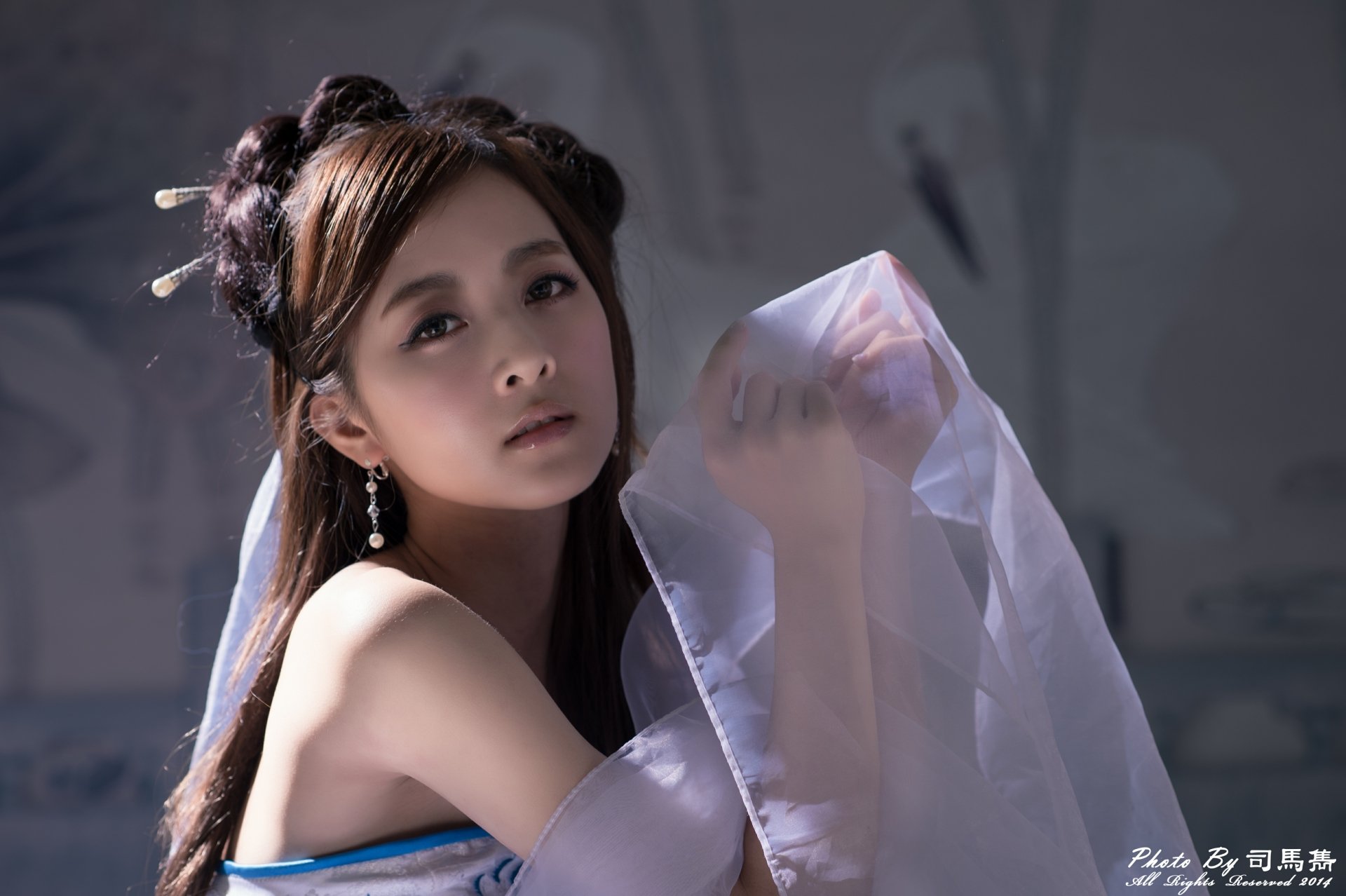 A serene Taiwanese woman adorned with elegant earrings and a hairpin wears a flowing dress, captured in a stunning 4K Ultra HD wallpaper by Mikako Zhang Kaijie.