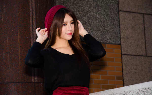 A smiling Taiwanese woman, Julie Chang, wearing a red beanie and black top, posing against a stone and brick background in this 4K Ultra HD desktop wallpaper.