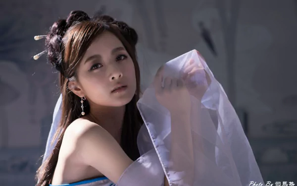 A serene Taiwanese woman adorned with elegant earrings and a hairpin wears a flowing dress, captured in a stunning 4K Ultra HD wallpaper by Mikako Zhang Kaijie.
