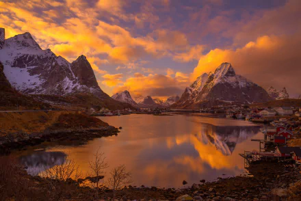 A stunning sunset over Reine village in Norway’s Lofoten Islands, reflecting vibrant colors against majestic mountains and tranquil waters, creating a breathtaking Scandinavian landscape.