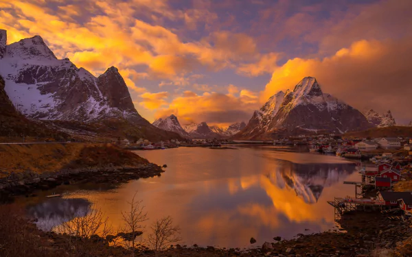 A stunning sunset over Reine village in Norway’s Lofoten Islands, reflecting vibrant colors against majestic mountains and tranquil waters, creating a breathtaking Scandinavian landscape.