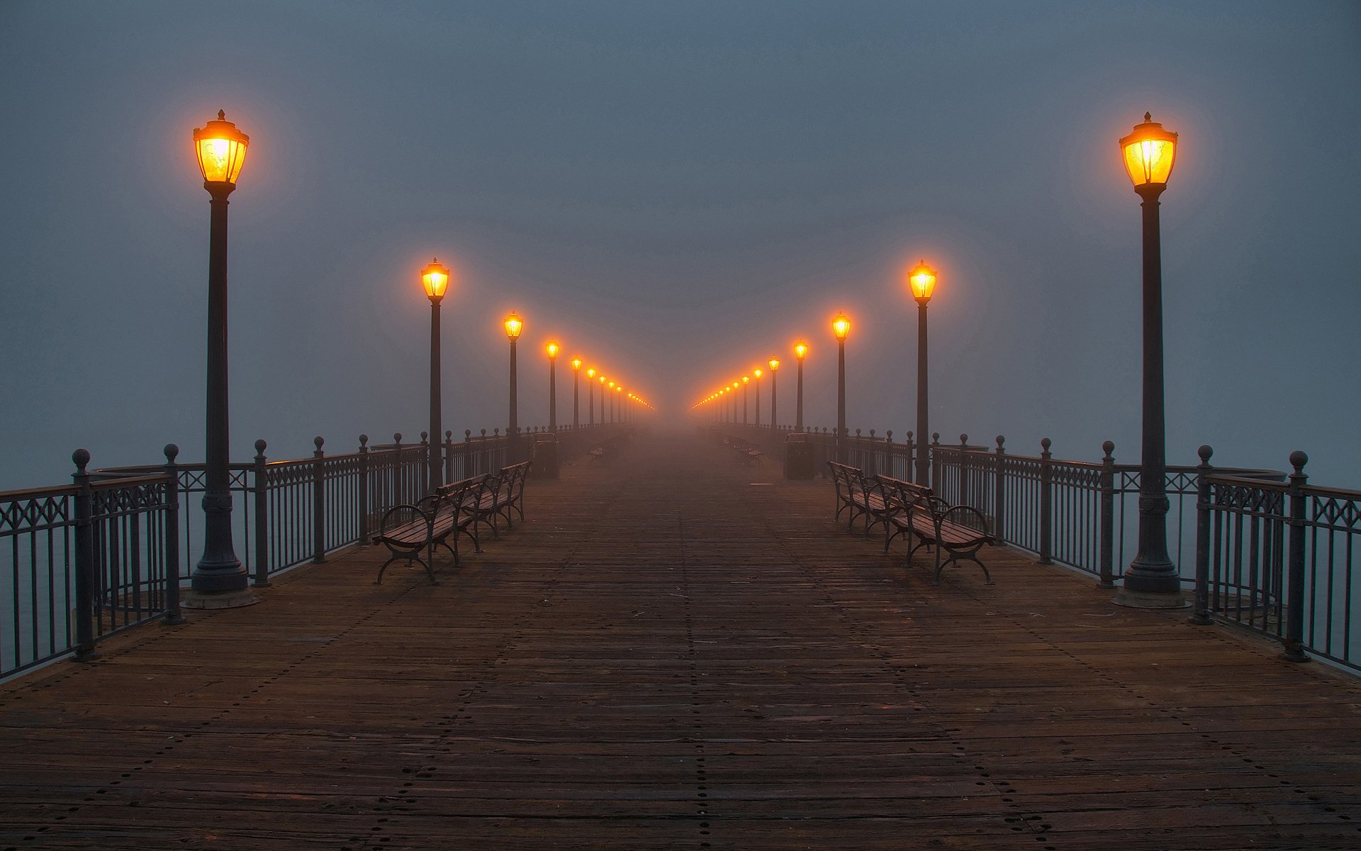 HD wallpaper featuring a misty evening at Pier 7 in San Francisco, with illuminated lamps lining the wooden pier.